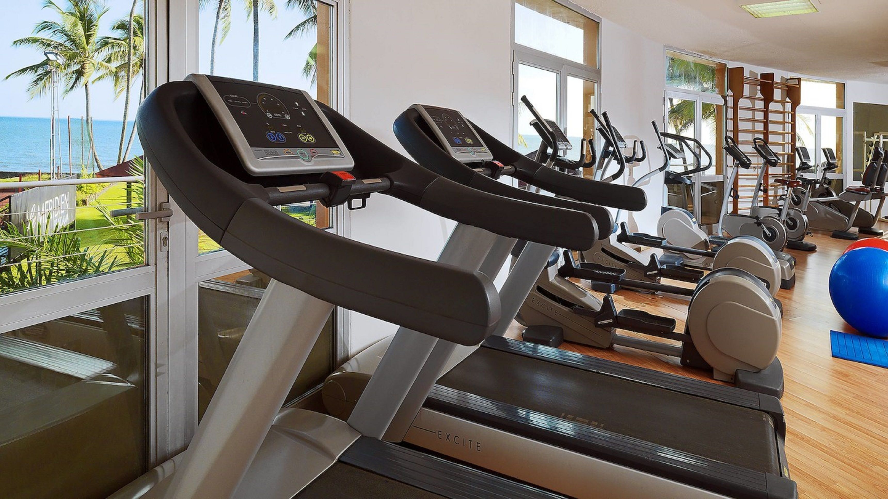 A gym with treadmills, exercise bikes, and weights.