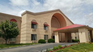 A building with a beige facade, large arched windows, and a red roof.