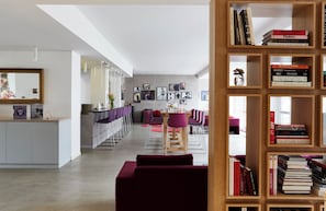 A modern interior with a dining area, a bookshelf, and a mirror.