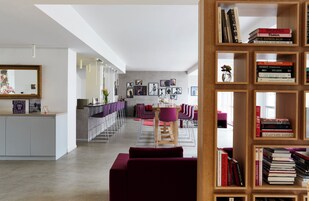 Ein modernes Interieur mit Essbereich, Bücherregal und Spiegel.