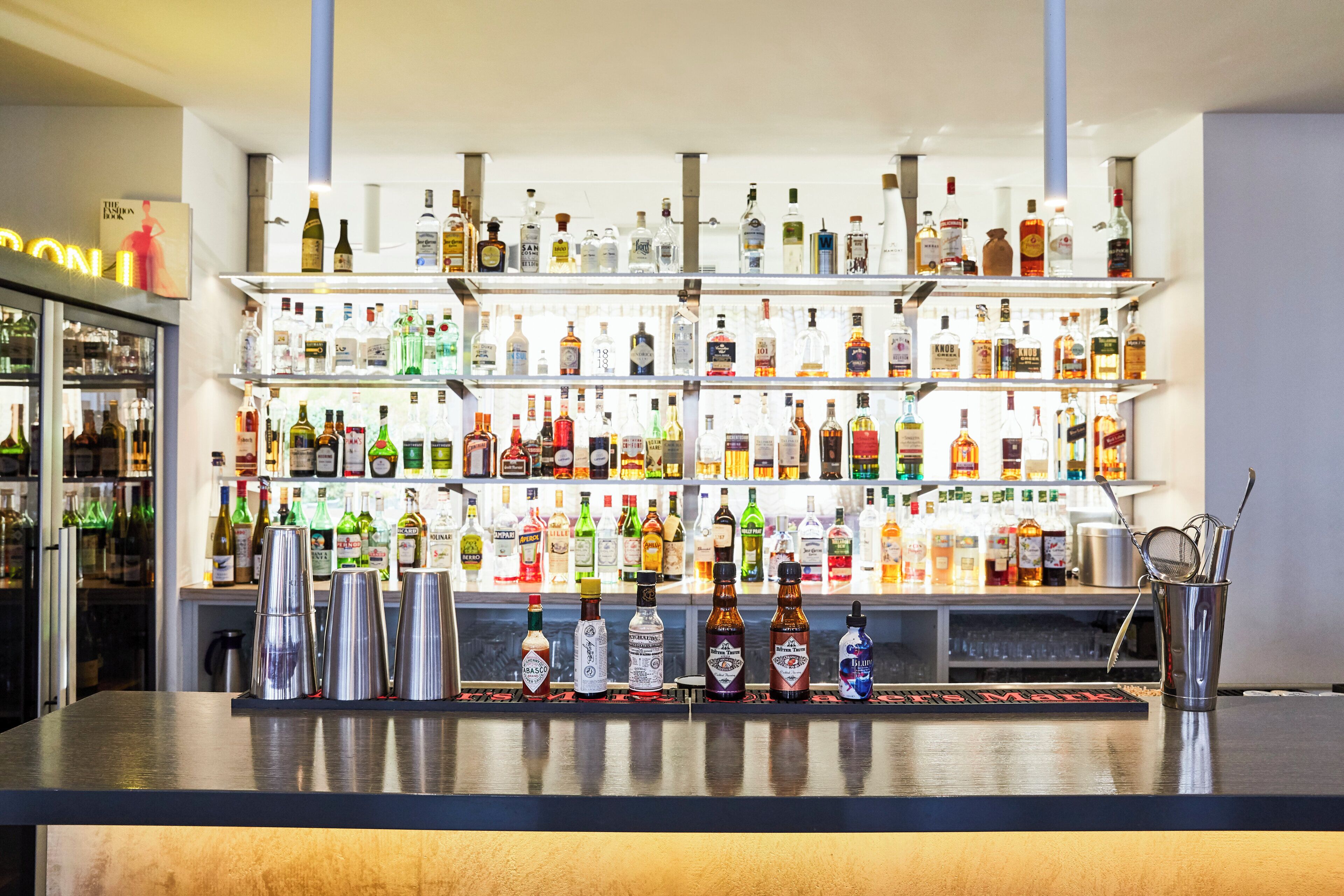 A bar with multiple shelves stocked with various liquor bottles.