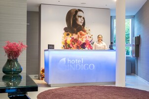 A hotel reception desk with a large floral advertisement and a modern interior design.