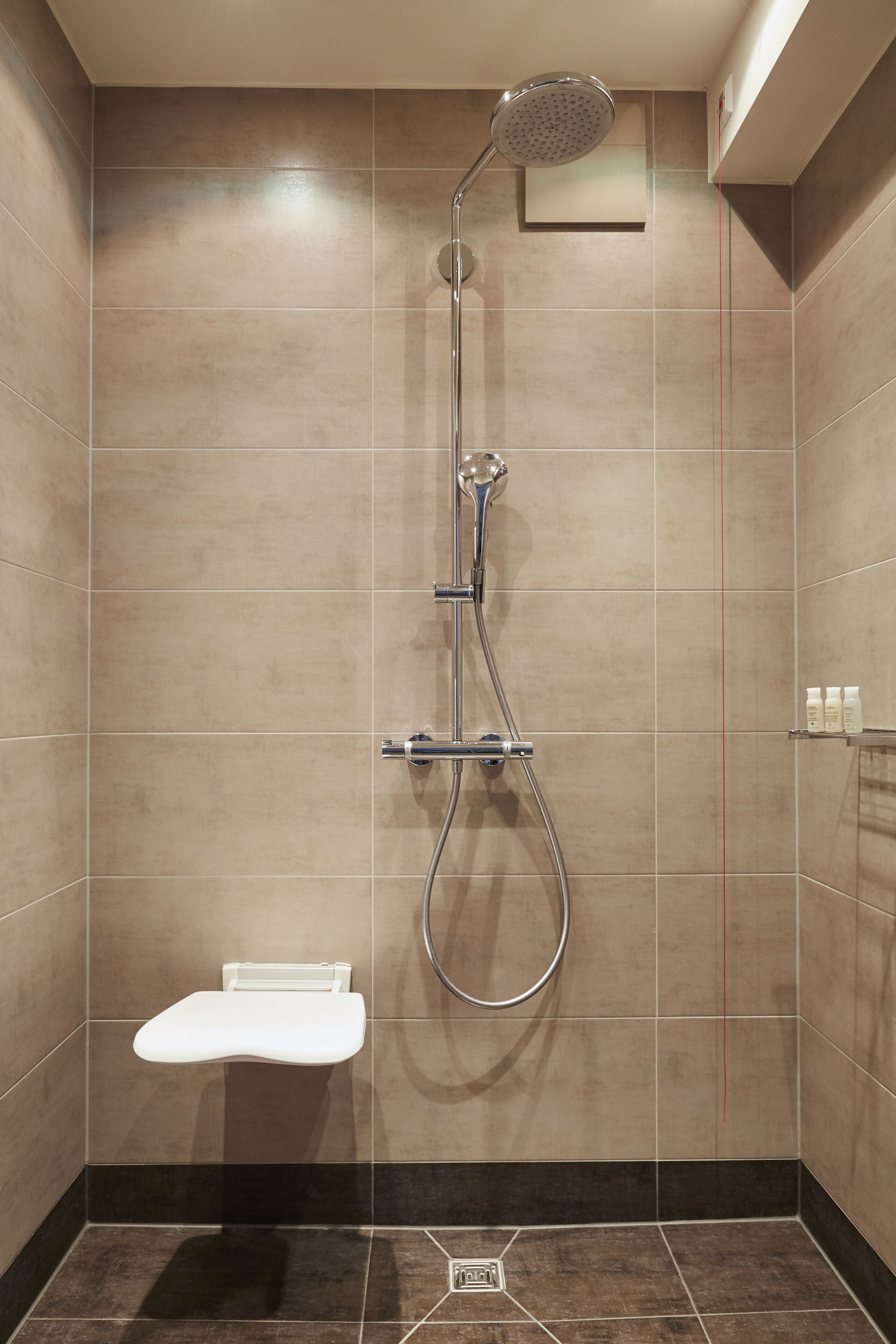 Ducha moderna con cabezal de ducha manual y grifo empotrado.