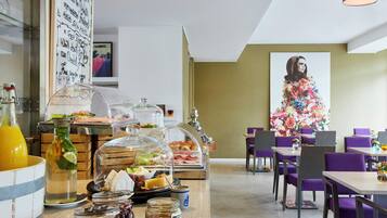 Un buffet de petit-déjeuner proposant une variété d’aliments et une grande œuvre d’art florale accrochée au mur.