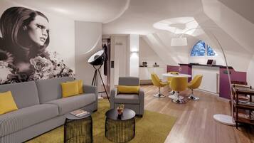 Un salon moderne comprenant un canapé, des fauteuils, une table basse et un coin repas avec une table et des chaises.