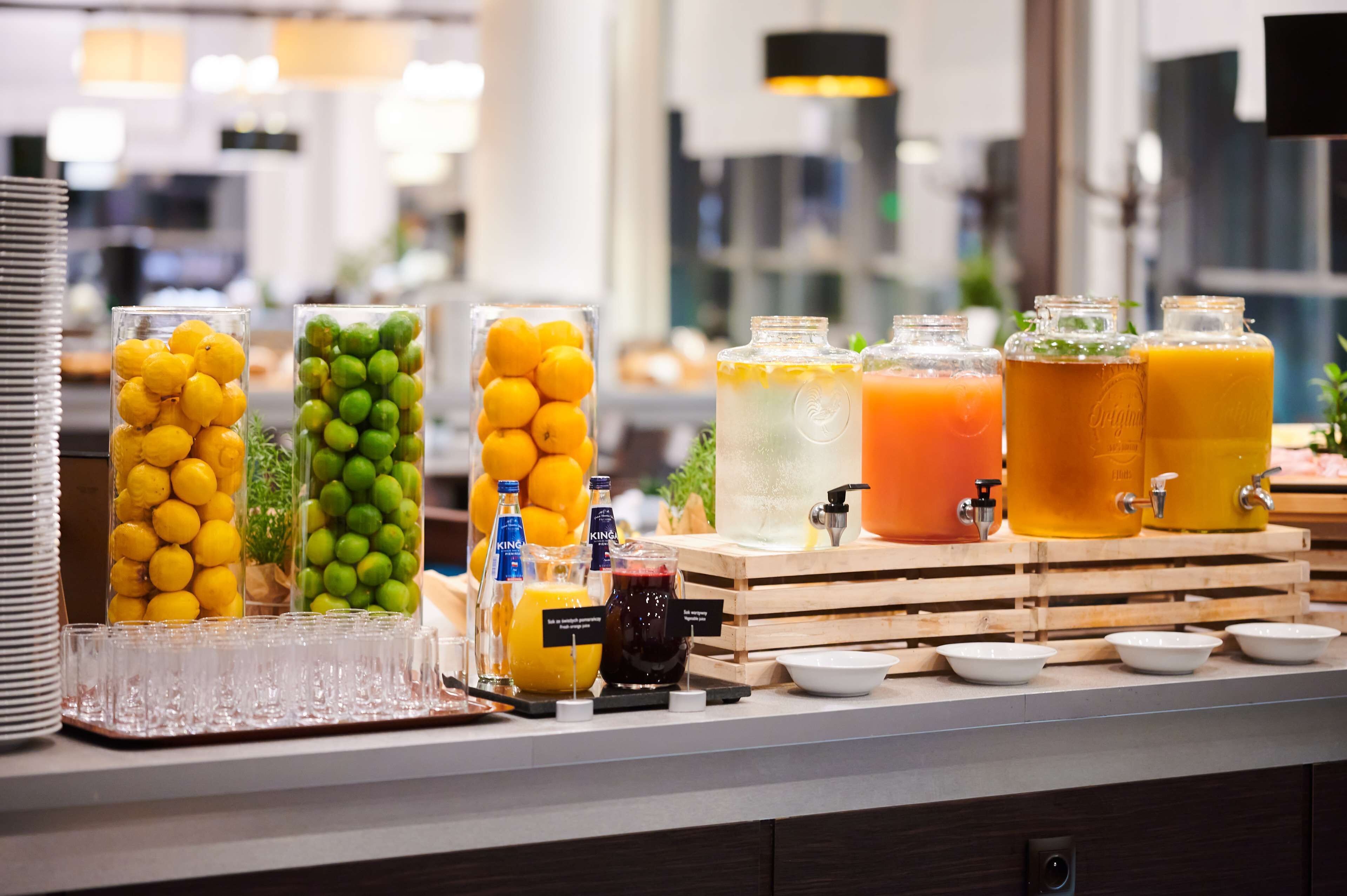 A buffet setup with various beverages and fruits.