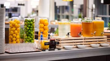 A buffet setup with various beverages and fruits.