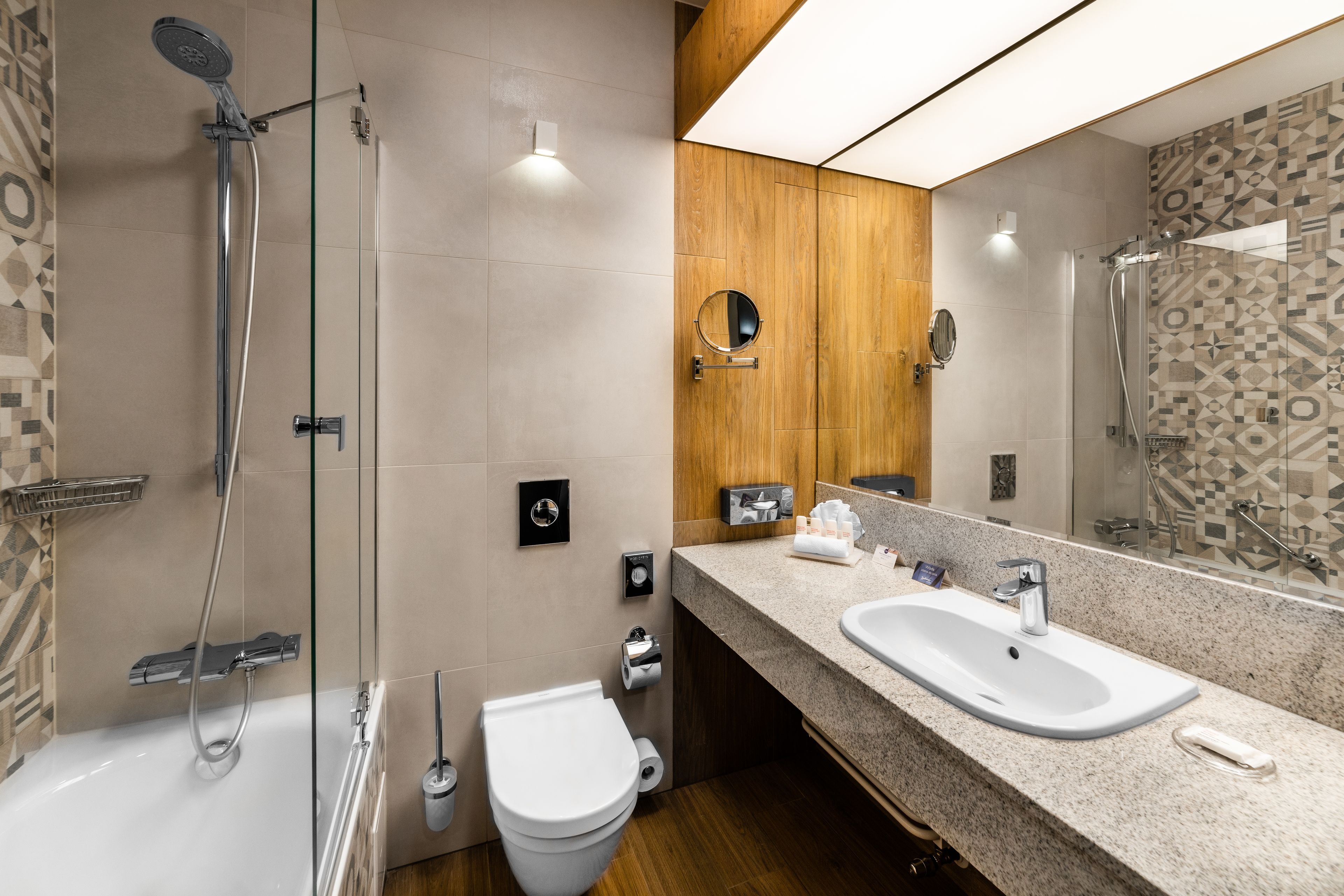A modern bathroom with a shower, toilet, and sink.