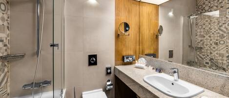 A modern bathroom with a shower, toilet, and sink.