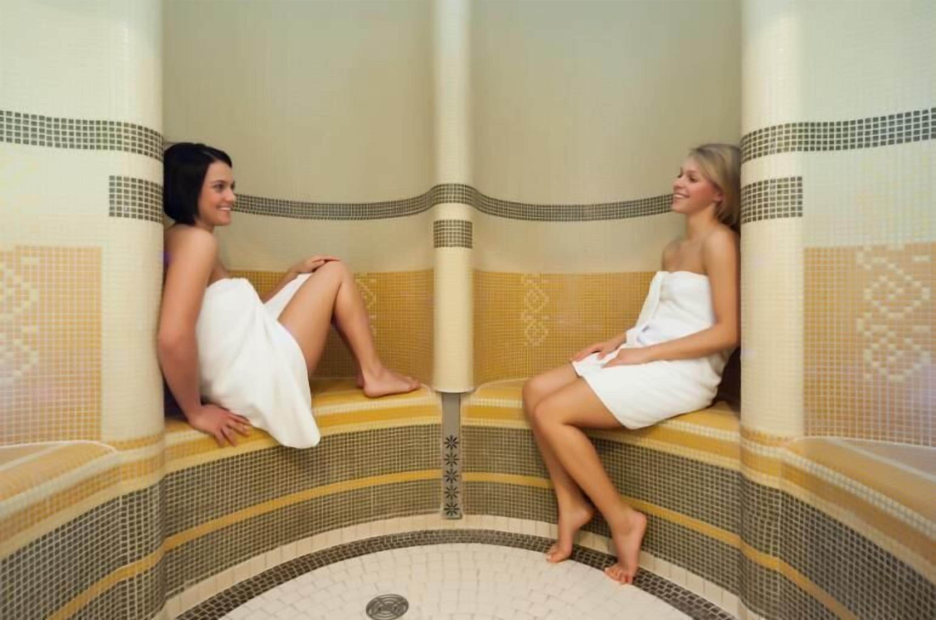 Dos jacuzzis con azulejos estampados y una columna central.