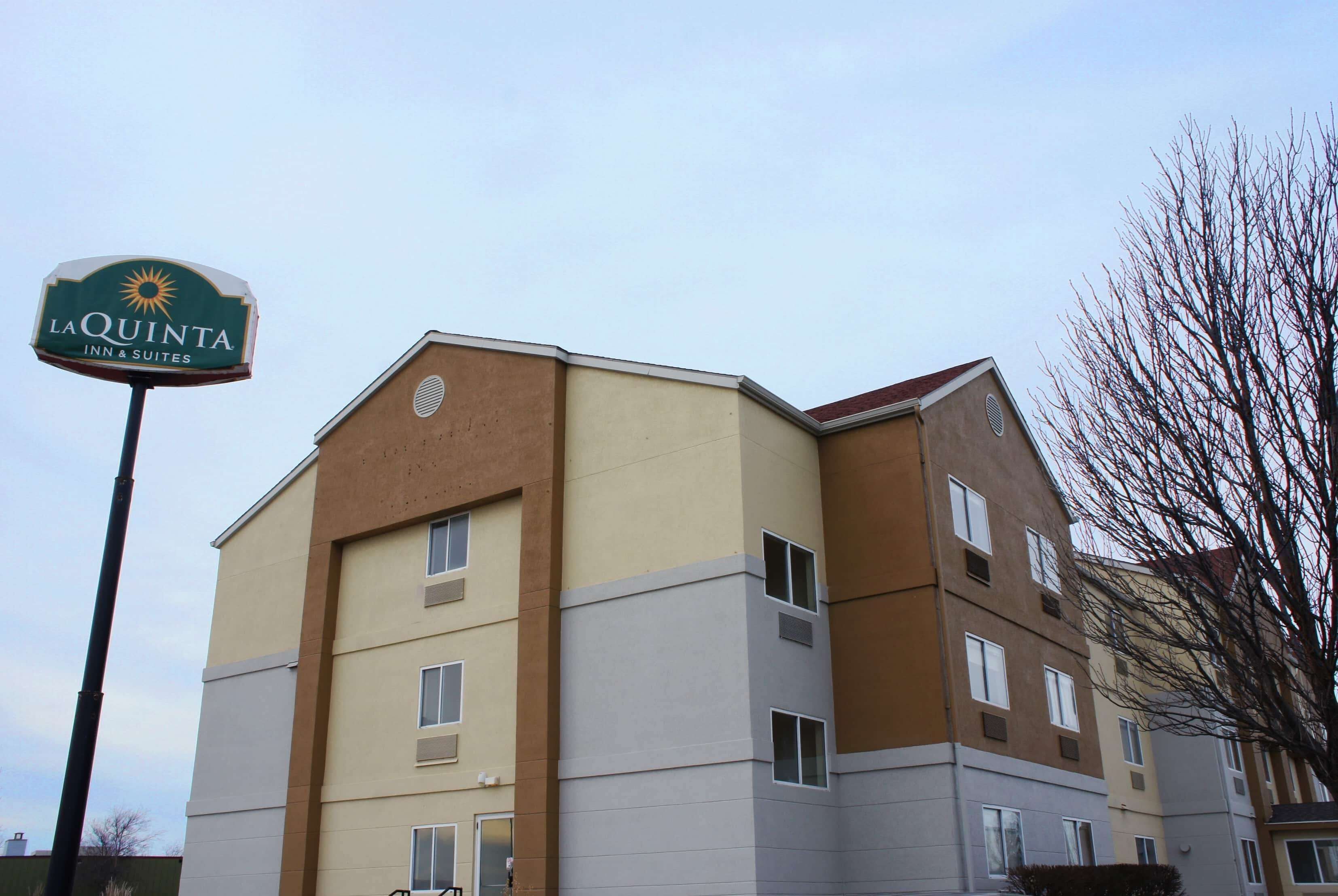 A multi-story hotel building with a sign for La Quinta Inn & Suites.