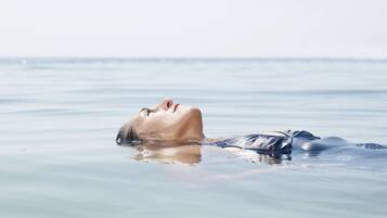 Una persona recostada en la playa.