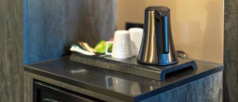 A coffee machine on a countertop with a control panel below it.