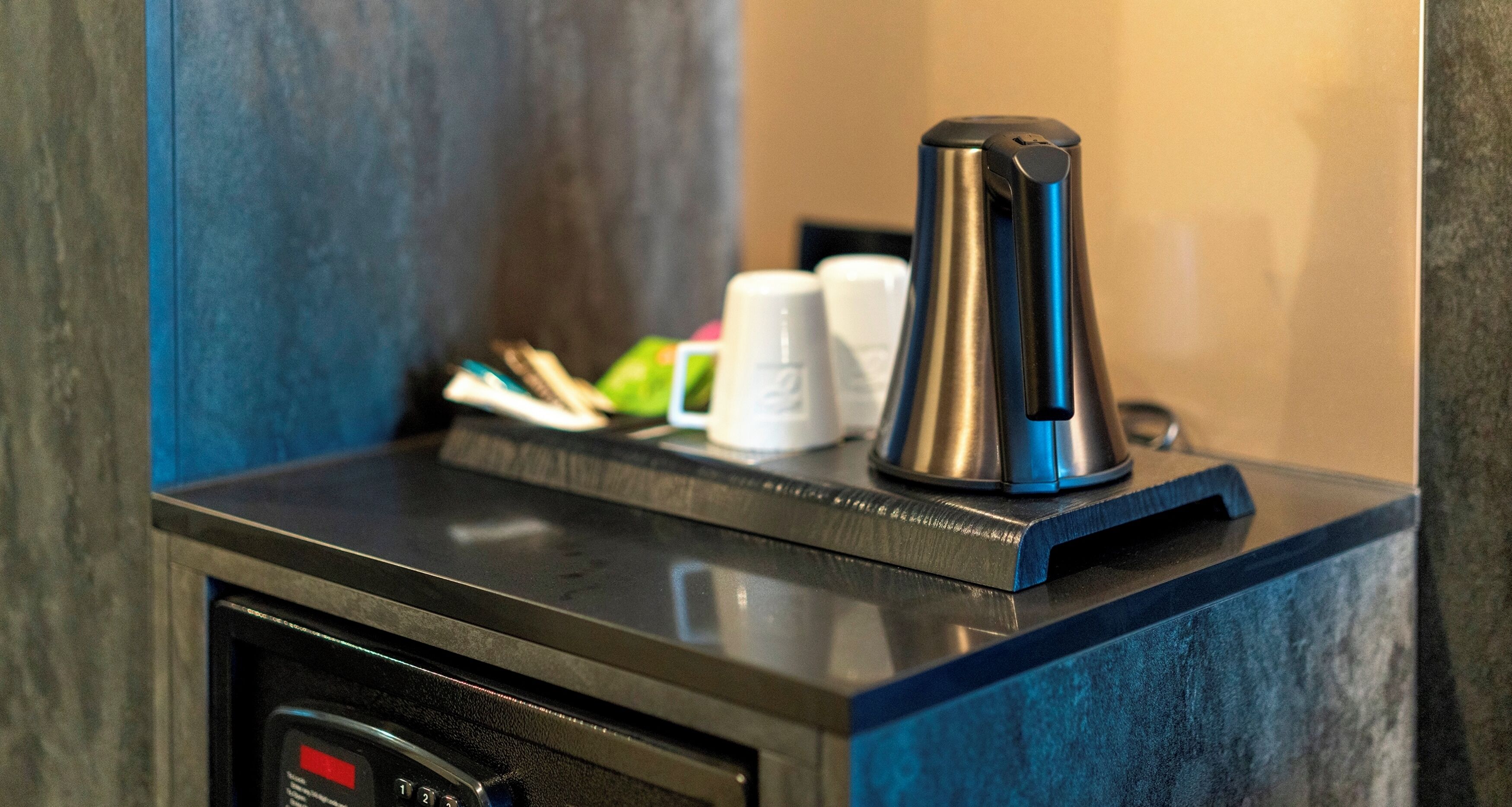 A coffee machine on a counter with a microwave below it.