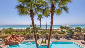 A pool with palm trees, a beach, and a sign for 'Calipso Spa'.