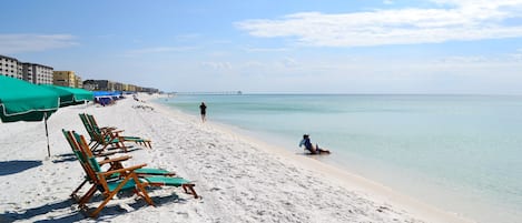 Am Strand, weißer Sandstrand, Liegestühle, Sonnenschirme