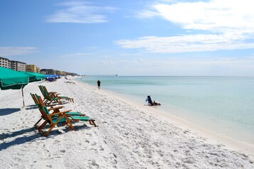 Plage, sable blanc, chaises longues, parasols