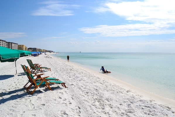 Am Strand, weißer Sandstrand, Liegestühle, Sonnenschirme