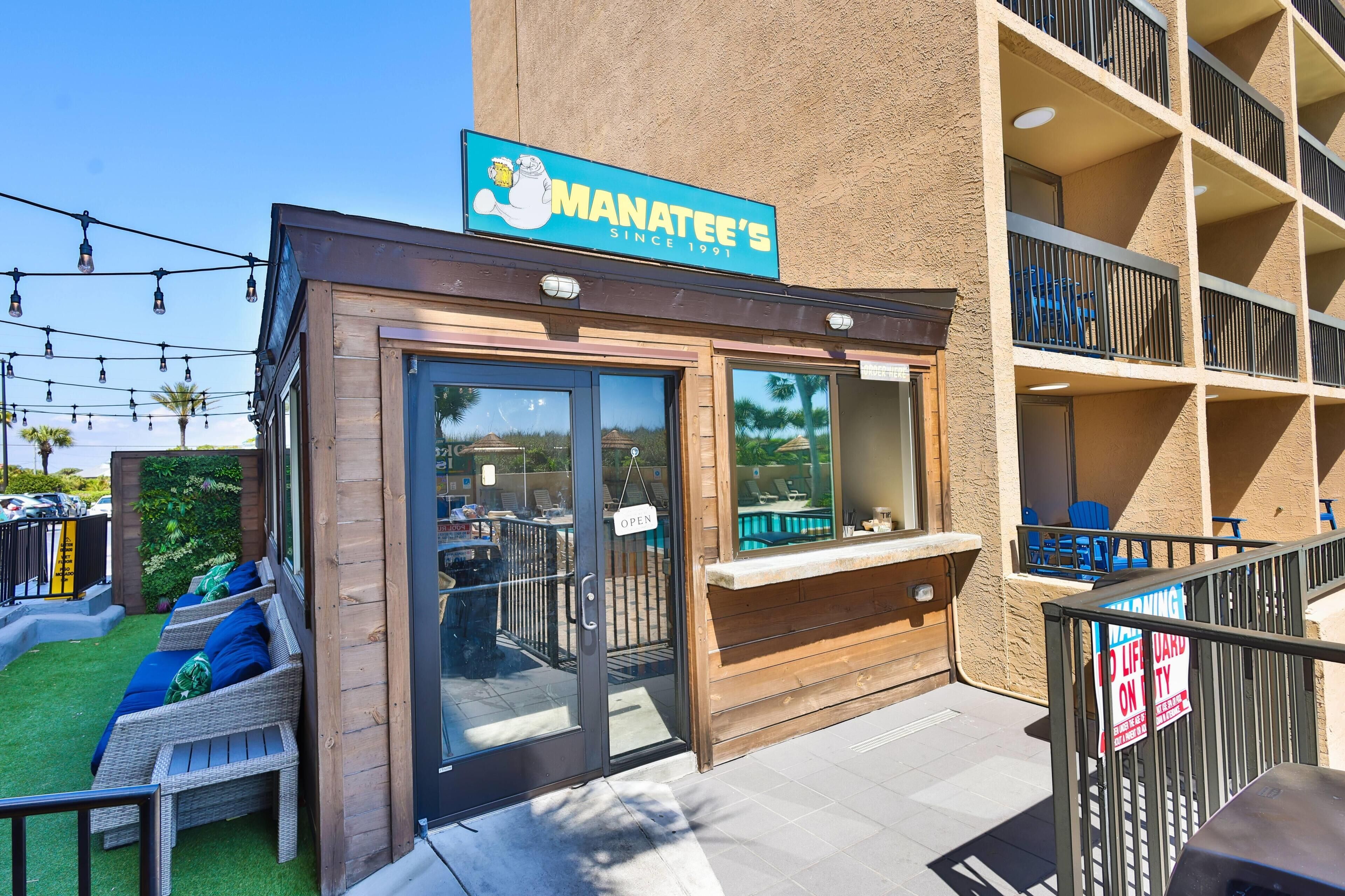 A restaurant named Manatee's with outdoor seating and a sign indicating it's open.