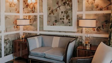 A room with a sofa, two lamps, and a framed picture on the wall.