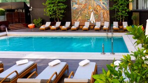 Un área de piscina con sillones de descanso y un mural.