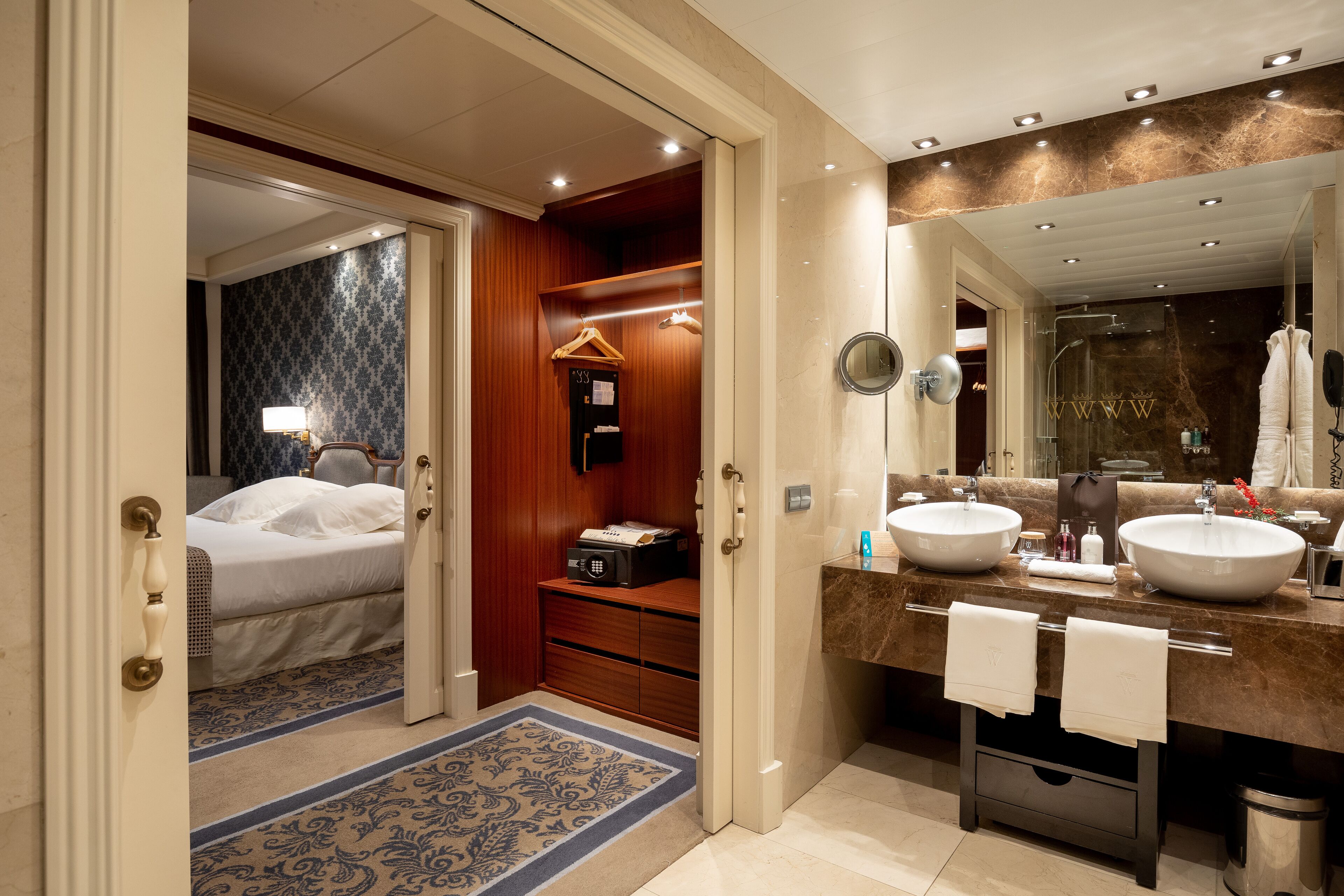 Un baño de hotel con dos lavamanos, un espejo grande y una ducha a pie.