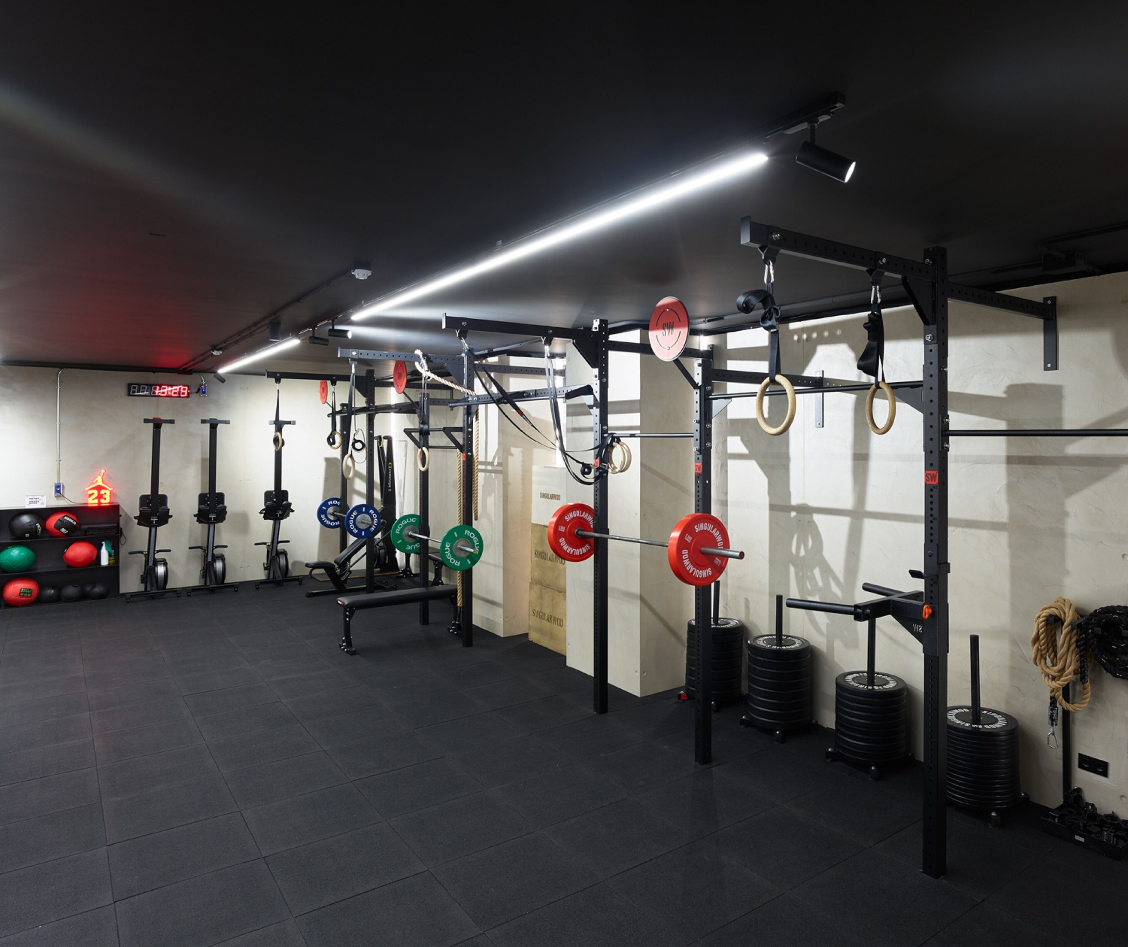 A gym with weightlifting equipment, including barbells, weight plates, and resistance bands.