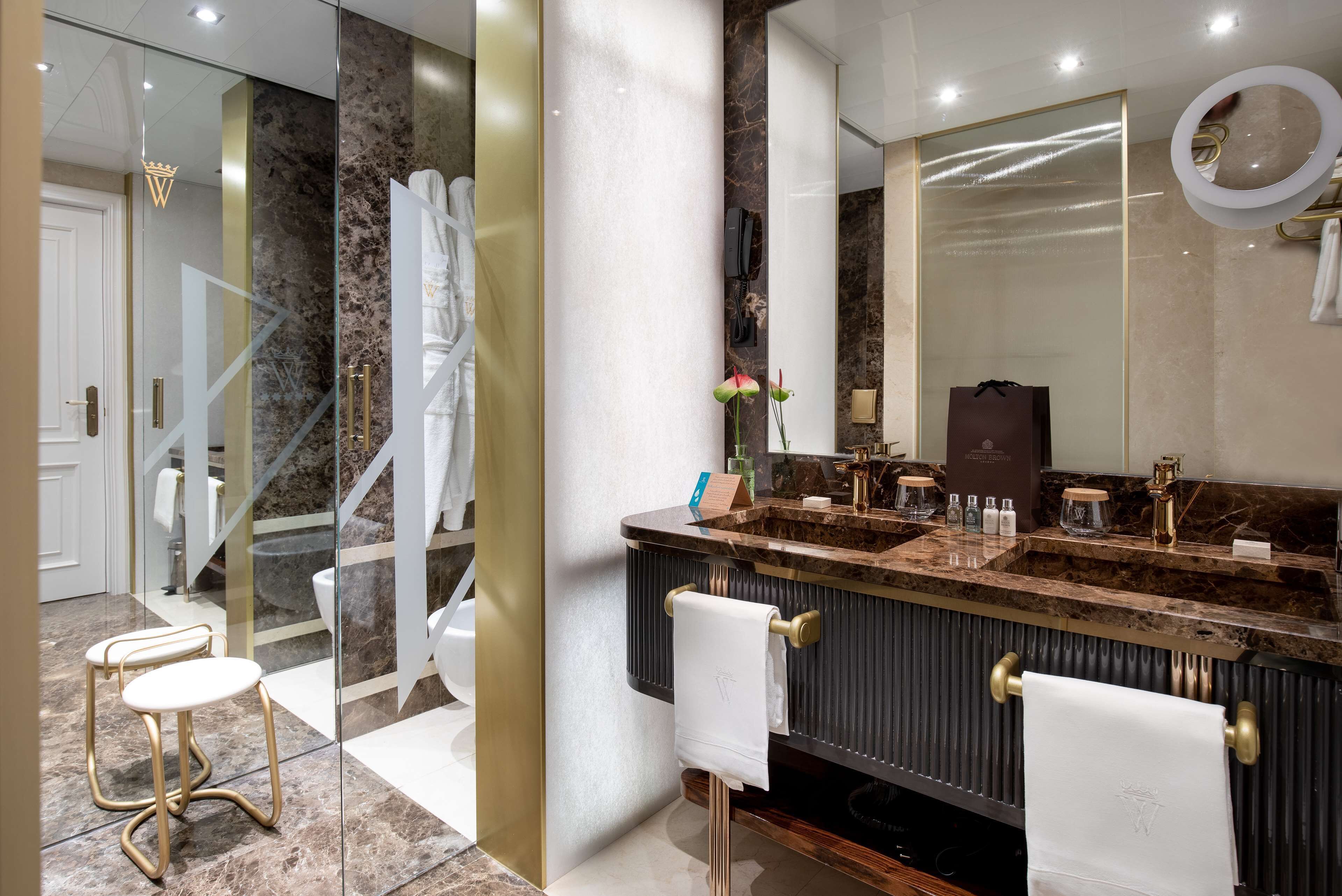 Une salle de bain moderne avec un meuble-lavabo en marbre, deux vasques et un grand miroir.