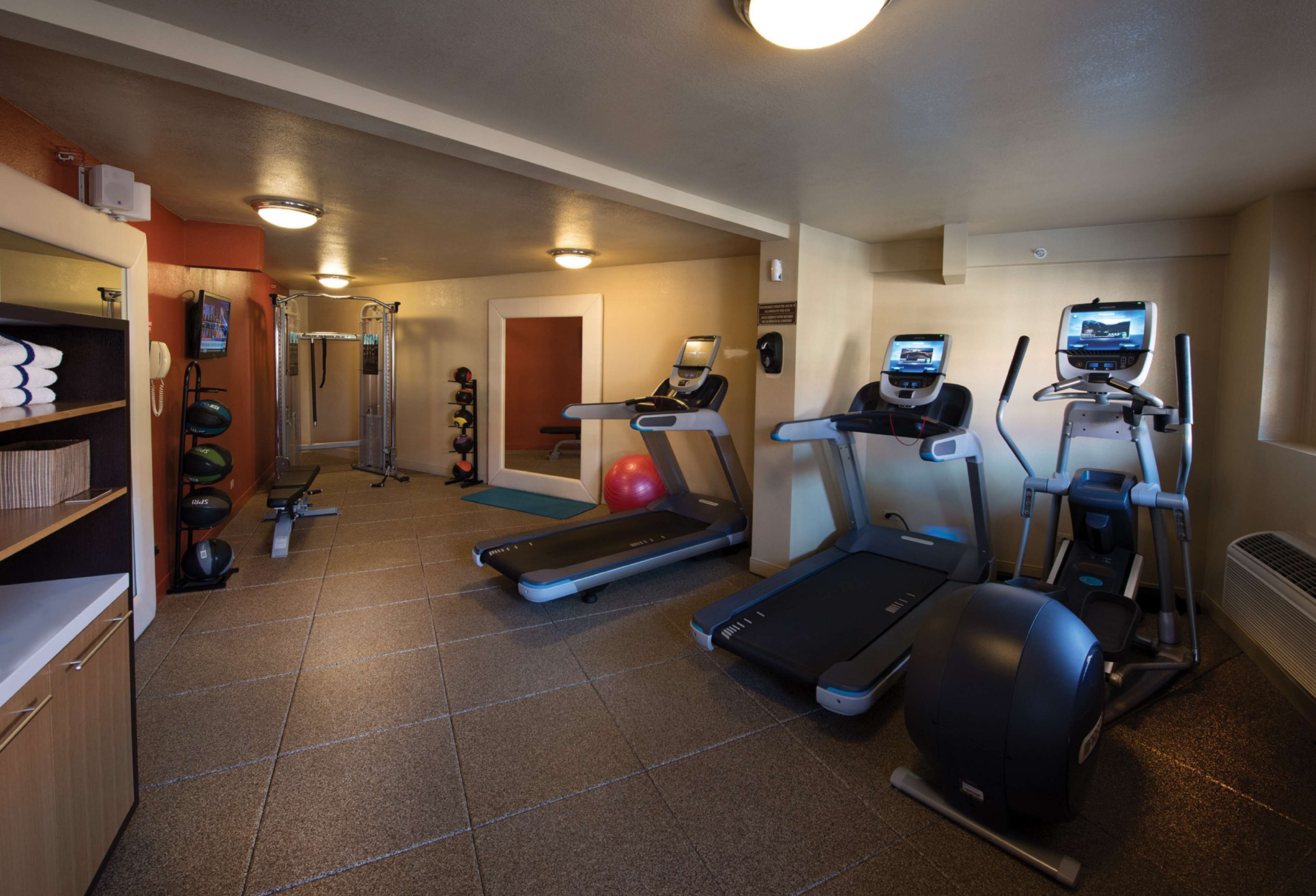 A gym with treadmills, elliptical machines, and a stationary bike.
