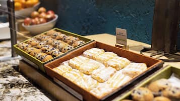 Una vetrina di panetteria con diverse preparazioni da forno, tra cui muffin e dolci, disposti in scatole di legno.