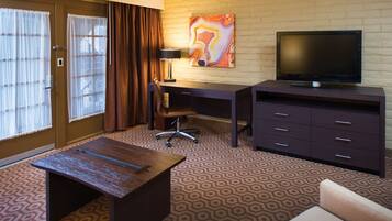 Une chambre d’hôtel équipée d’un bureau, d’une chaise, d’une télévision et d’une petite table.