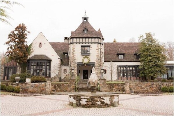 A historic building with a central tower, stone walls, and a paved courtyard. - Holiday Inn & Suites Parsippany Fairfield by IHG (Parsippany)