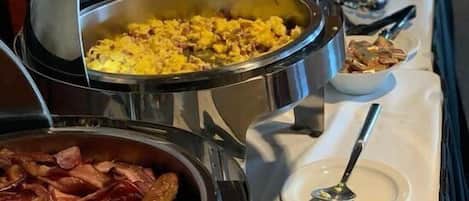 A buffet with various dishes in metal serving containers.