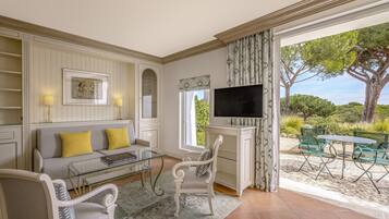 A living room with a sofa, chairs, a TV, and a view of the outdoors.