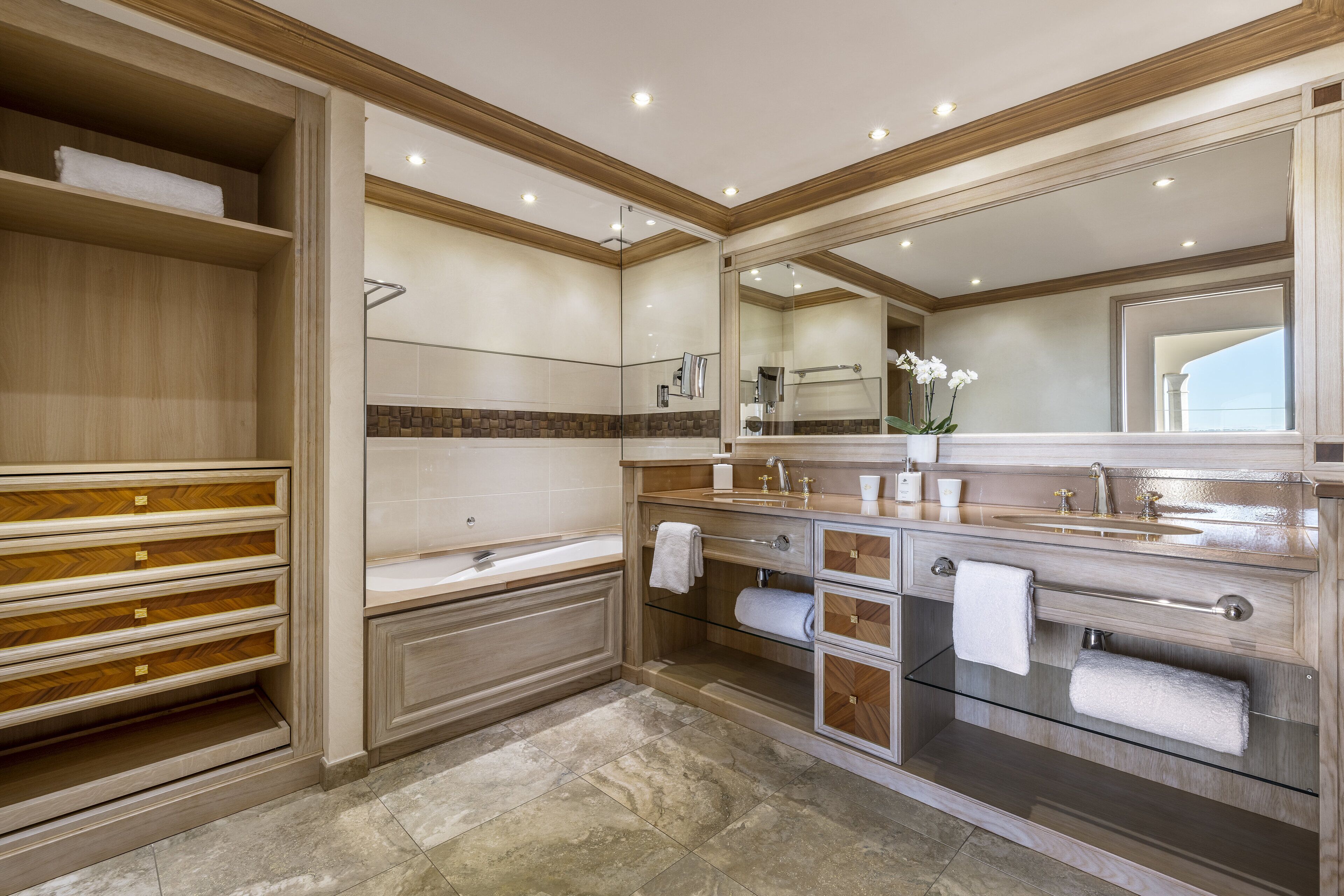 A spacious bathroom with a large bathtub, a glass-enclosed shower, and a vanity with a mirror.