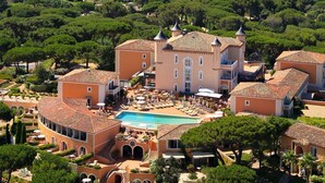 Un resort con piscina, varias edificaciones y vista al mar.