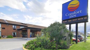 A Comfort Inn sign with a clear view of the building's entrance and parking area.