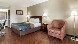 A hotel room with a bed, a chair, a desk, and a lamp. - Econo Lodge Conyers (Conyers)