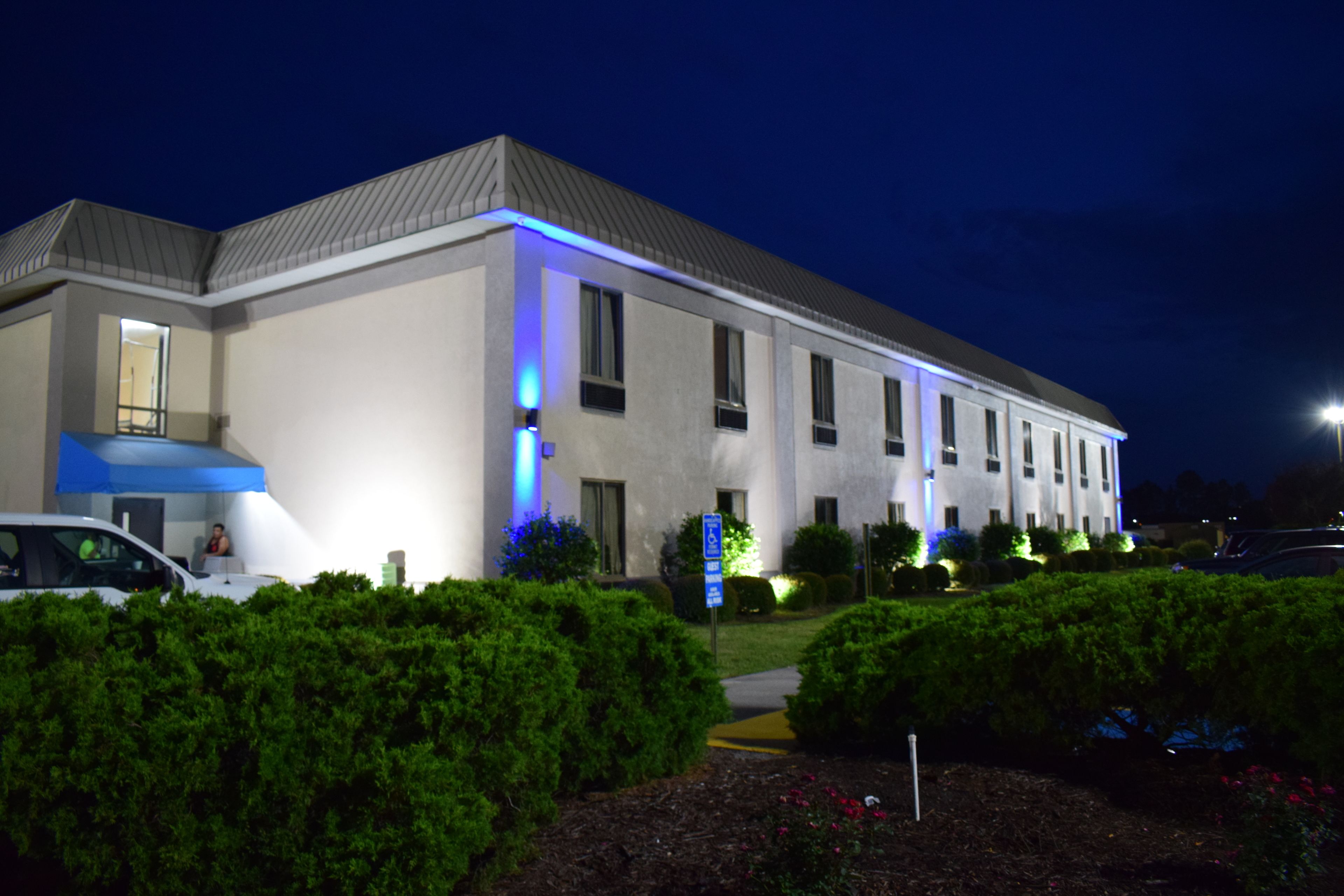 Un hotel de varios pisos con techo plano, amplias ventanas y fachada bien iluminada.