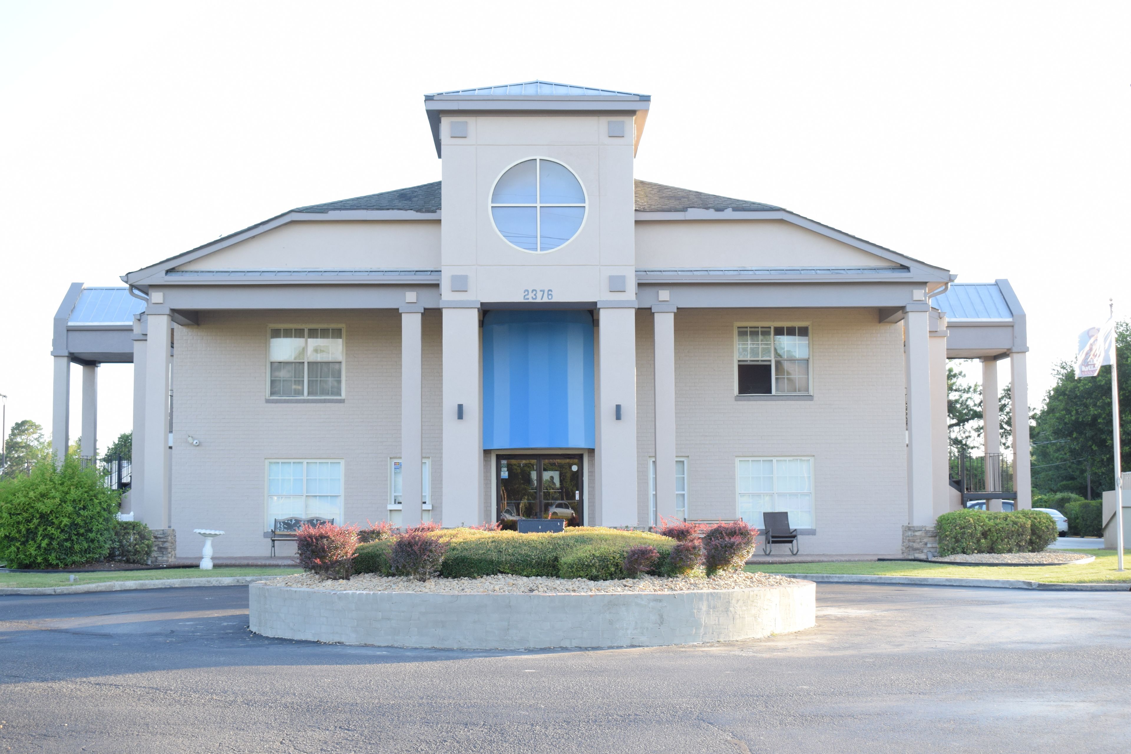 A modern building with a blue entrance, a circular window, and the number 2376.