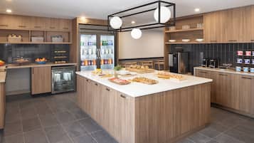 A modern kitchen with wooden cabinets, a central island, and a built-in refrigerator.
