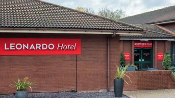 A brick building with a red sign reading 'LEONARDO Hotel'.
