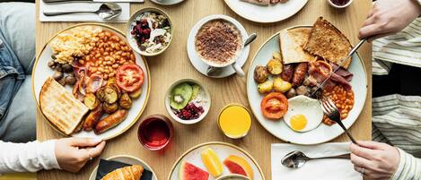 A breakfast setting with various dishes including toast, eggs, sausages, and a croissant.