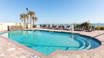 Una piscina al aire libre, sillones reclinables de piscina