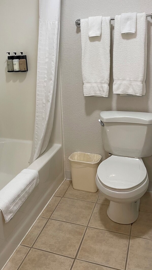 A bathroom with a bathtub, toilet, and a trash bin. - Antler Lodge - Gardiner MT (Gardiner)