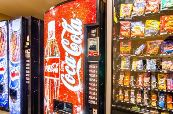 A vending machine with Coca-Cola branding and a variety of snacks.