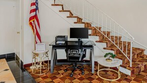 A home office with a desk, computer, and flag.