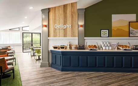A modern kitchen area with a blue island, wooden accents, and a sign that reads "Delight in the day."