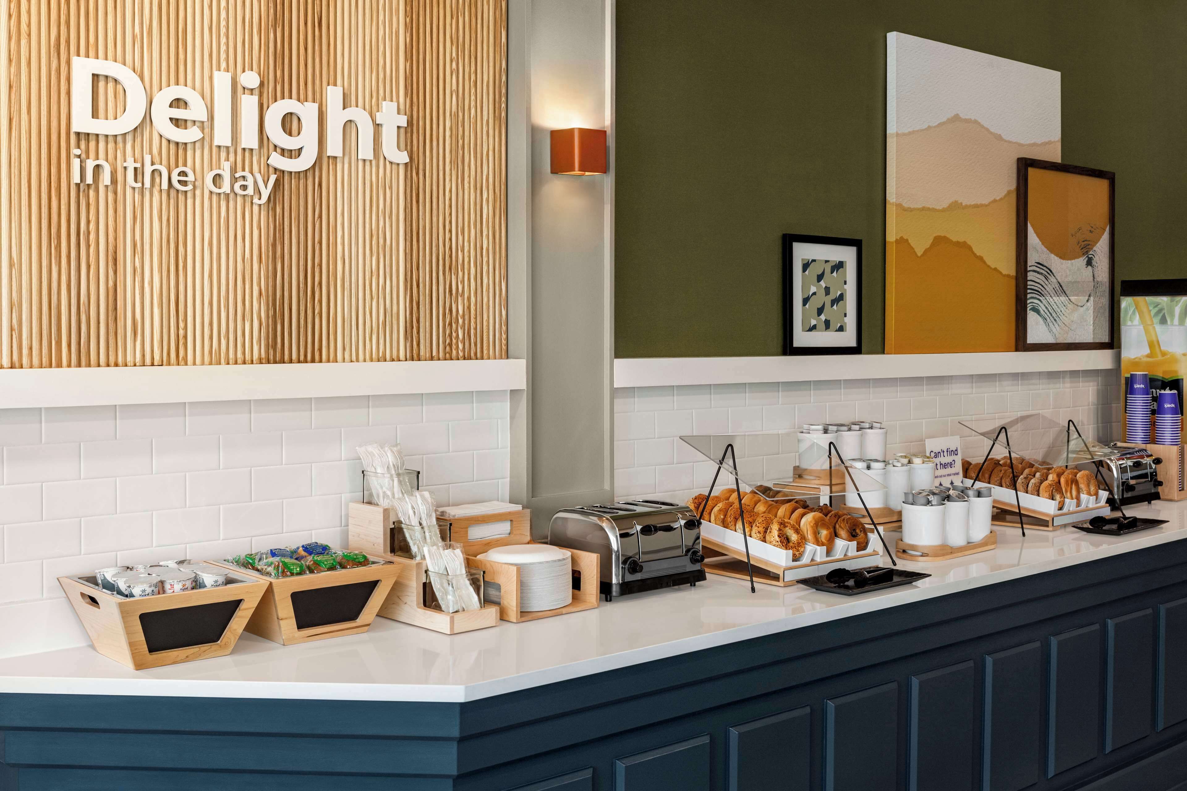 A breakfast bar with various food items and a sign that reads "Delight in the day".