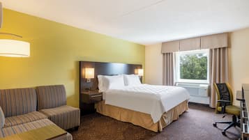 Una habitación de hotel con cama, sofá, escritorio y silla.